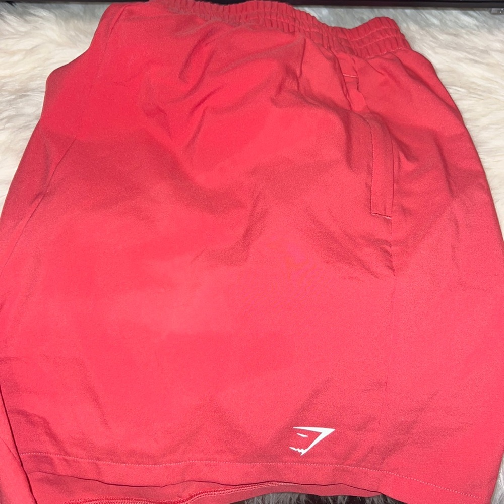 Salmon colored Gymshark running shorts